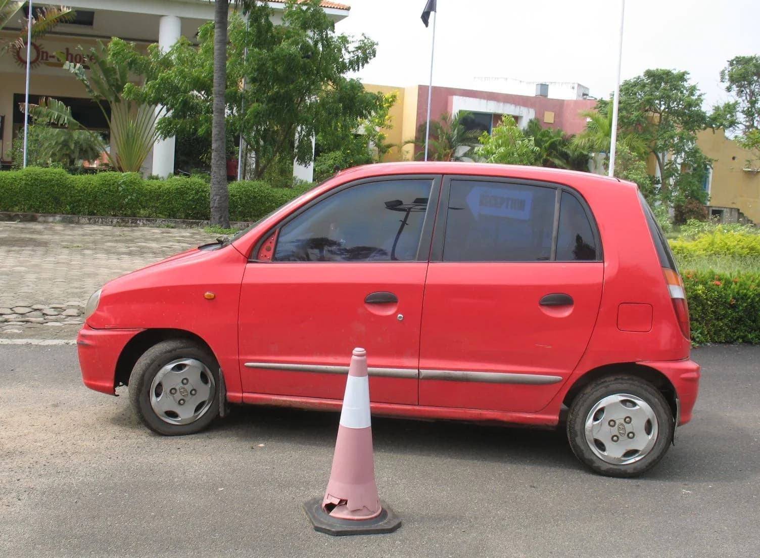 Red hatchback and pink cone