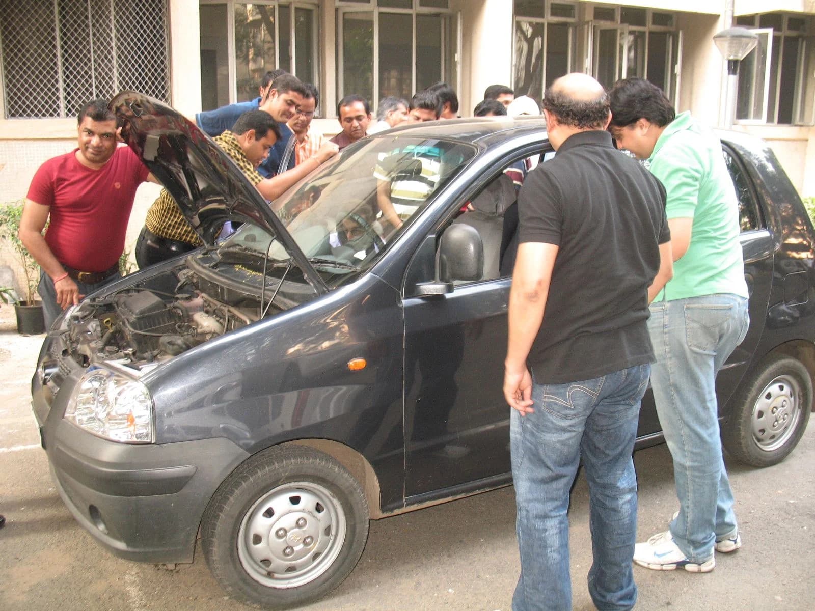 A group around an open bonnet learning engine checks
