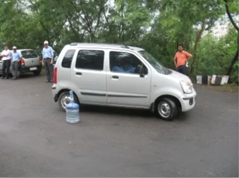 A hatchback stopping against a water-bottle marker