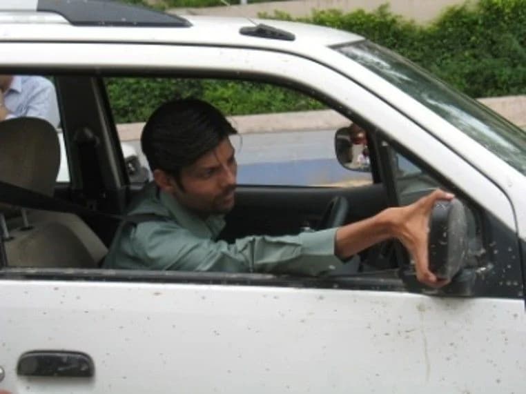 A driver adjusting the mirror before moving off